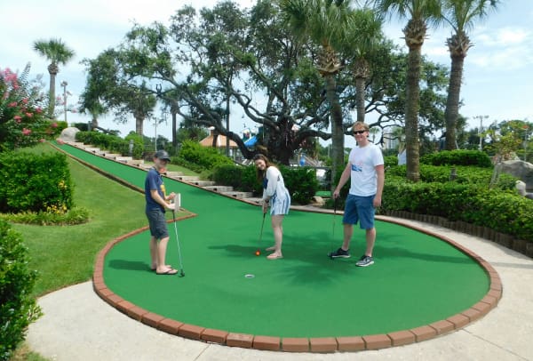 An image of a family having fun playing mini-golf at Coconut Creek in Panama City Beach, Florida.